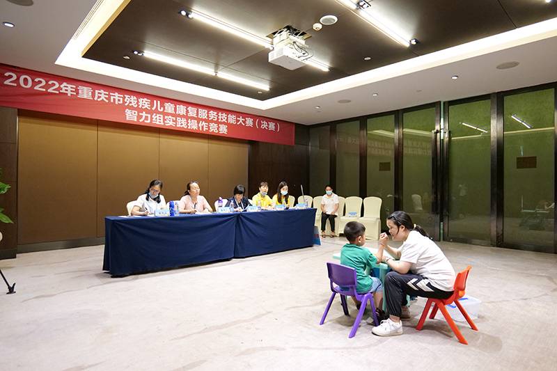 2022年重庆市残疾儿童康复服务技能大赛智力组比赛现场，参赛者正在给智力残疾儿童一对一授课。市残联供图