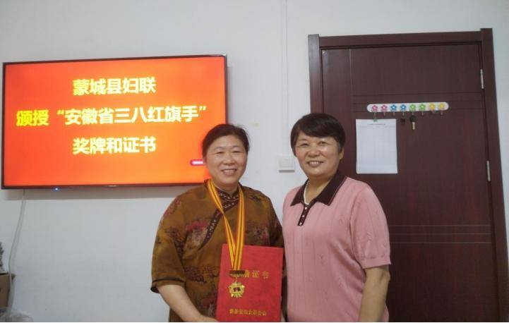 县妇联为“安徽省三八红旗手”获得者王奎芝颁发徽章及荣誉证书(图1)